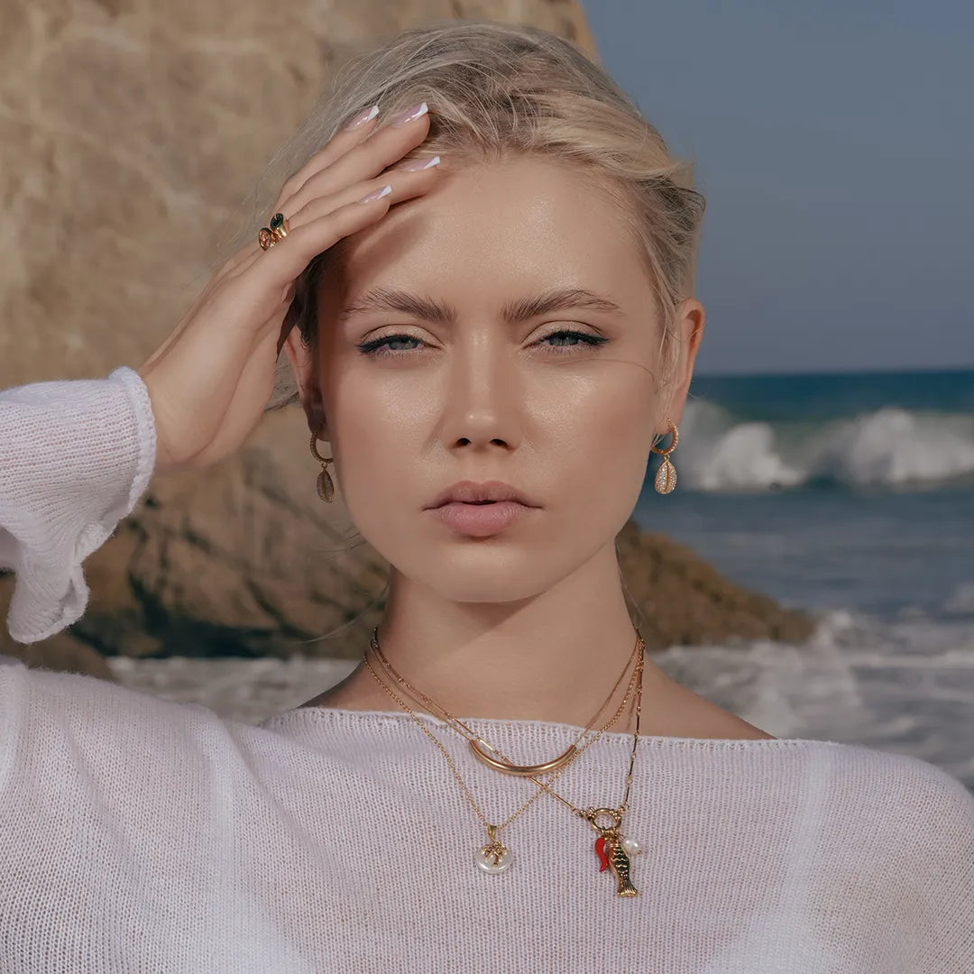 Model wearing Zard Jewelry Cowrie Shell Hoop Earrings in CZ Accent