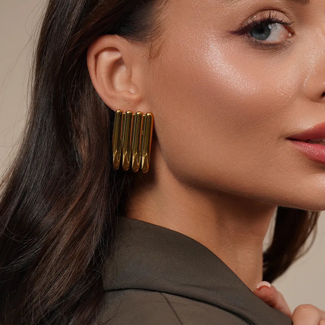 Model wearing Zard Jewelry Linear Sculpted Earrings in Gold and Silver