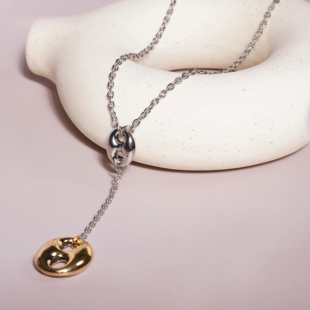 Lariat Necklace in Puffed Mariner Silver Gold Charm styled on a soft-toned background