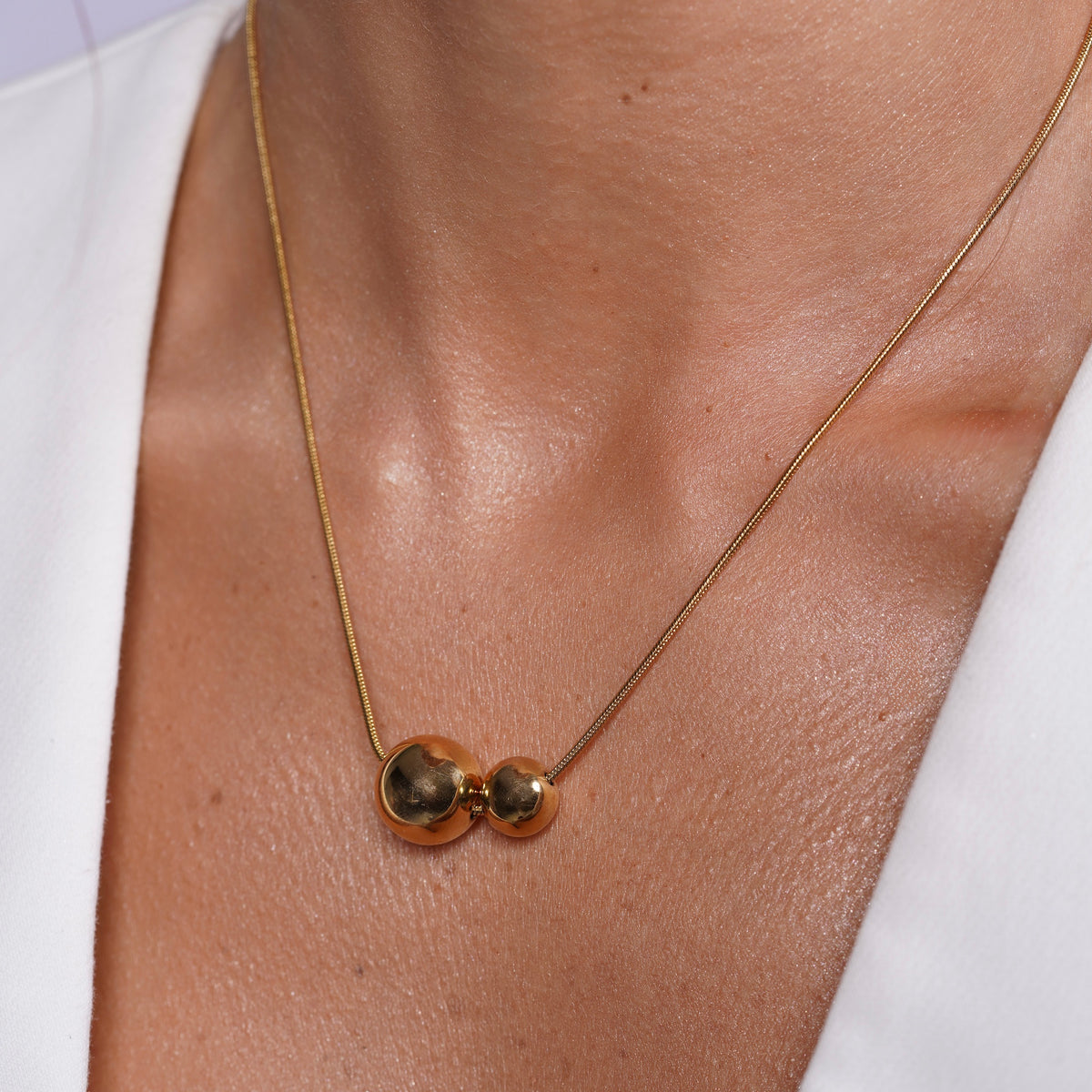 Model wearing Minimalist Double Gold Sphere Necklace Modern Dainty Bead Pendant around her neck