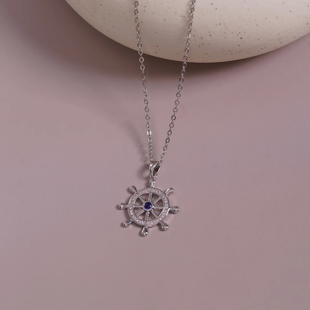 Ship-Wheel Pendant Necklace styled on a soft-toned background