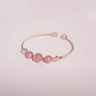 Rose Quartz Beaded Gold Open Wire Bracelet styled on a soft-toned background