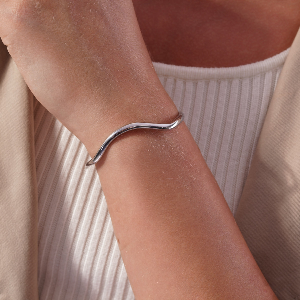 Sculptural Wave Open Cuff Bracelet worn on a model's wrist, alternate pose