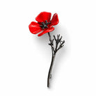 Red enamel poppy brooch with a dark metallic stem and branching leaves, front view.