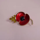 Red Enamel Poppy Flower Brooch Pin styled on a soft-toned background