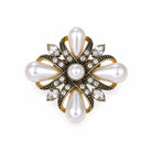 A vintage-style floral brooch featuring white pearls, gold-toned metal, and small clear crystals on a plain white background.
