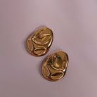 Hammered Statement Chunky Earrings In Gold and Silver styled on a soft-toned background