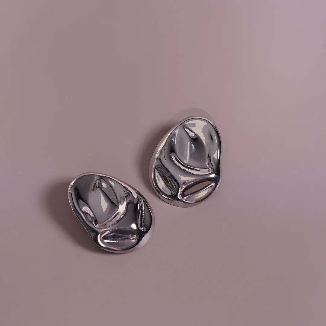 Hammered Statement Chunky Earrings In Gold and Silver styled on a soft-toned background, alternate angle