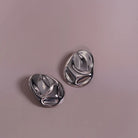 Hammered Statement Chunky Earrings In Gold and Silver styled on a soft-toned background, alternate angle