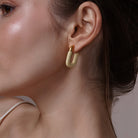 Model wearing Large Enamel Oval Hoop Earrings, styled look
