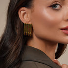 Model wearing Zard Jewelry Linear Sculpted Earrings in Gold and Silver