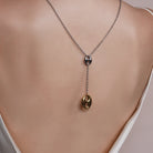 Model wearing Lariat Necklace in Puffed Mariner Silver Gold Charm around her neck, alternate pose