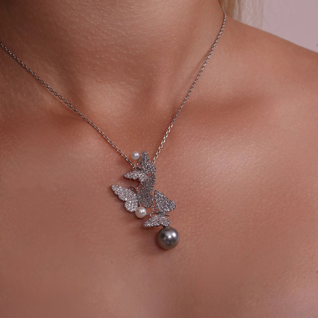 Model wearing Triple Butterfly CZ and Pearl Charm Necklace around her neck