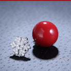 Snowflake and Reindeer Red Bead Christmas Asymmetric Stud Earring styled on a soft-toned background, alternate angle
